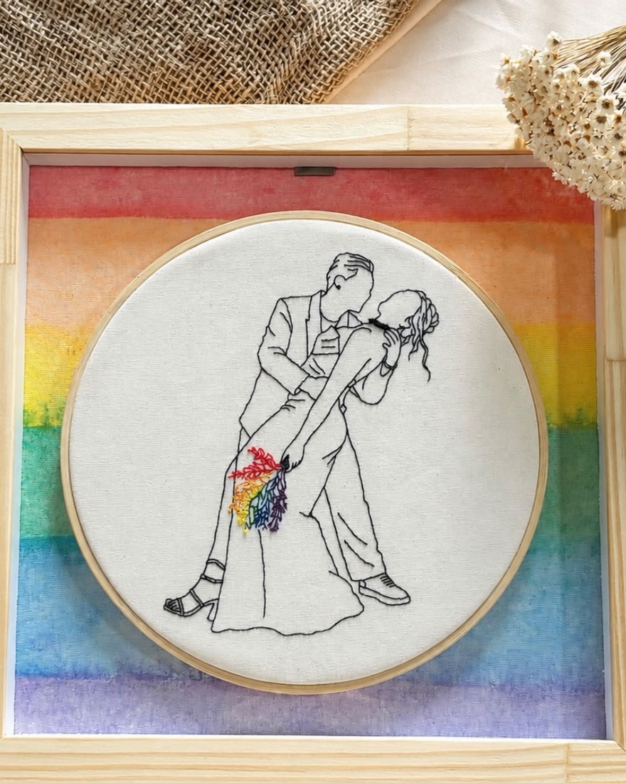 Quadro de madeira com fundo em aquarela arco-íris e bastidor bordado com casal dançando